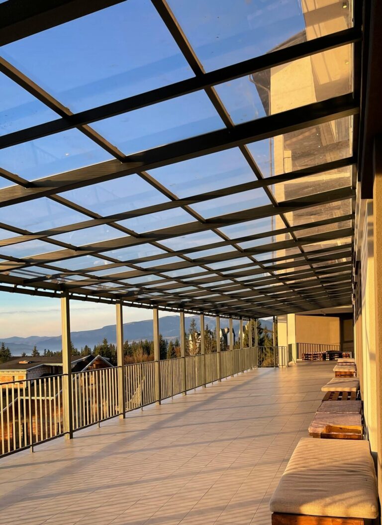 Spacious terrace in Yaremche, Ukraine, with a glass roof and benches, offering scenic mountain views.