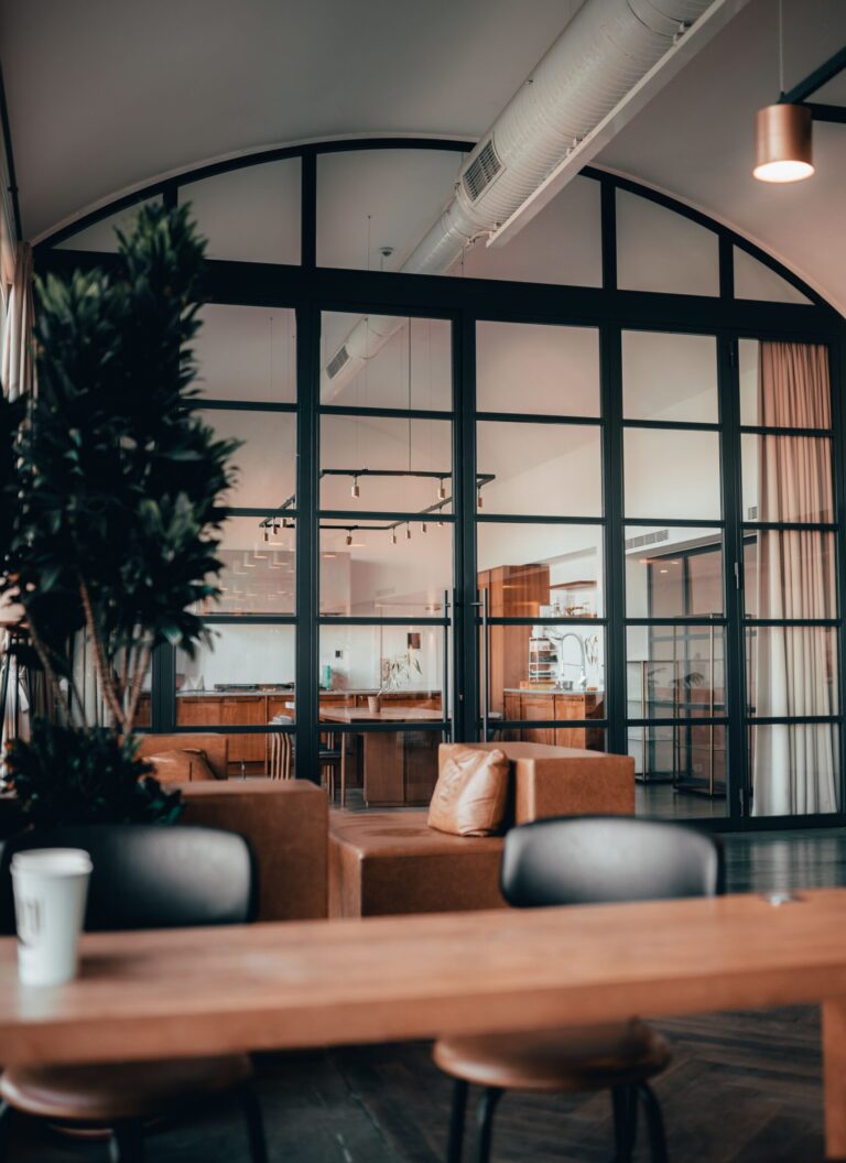 A stylish open office with glass partitions featuring leather furniture and a homely ambiance.